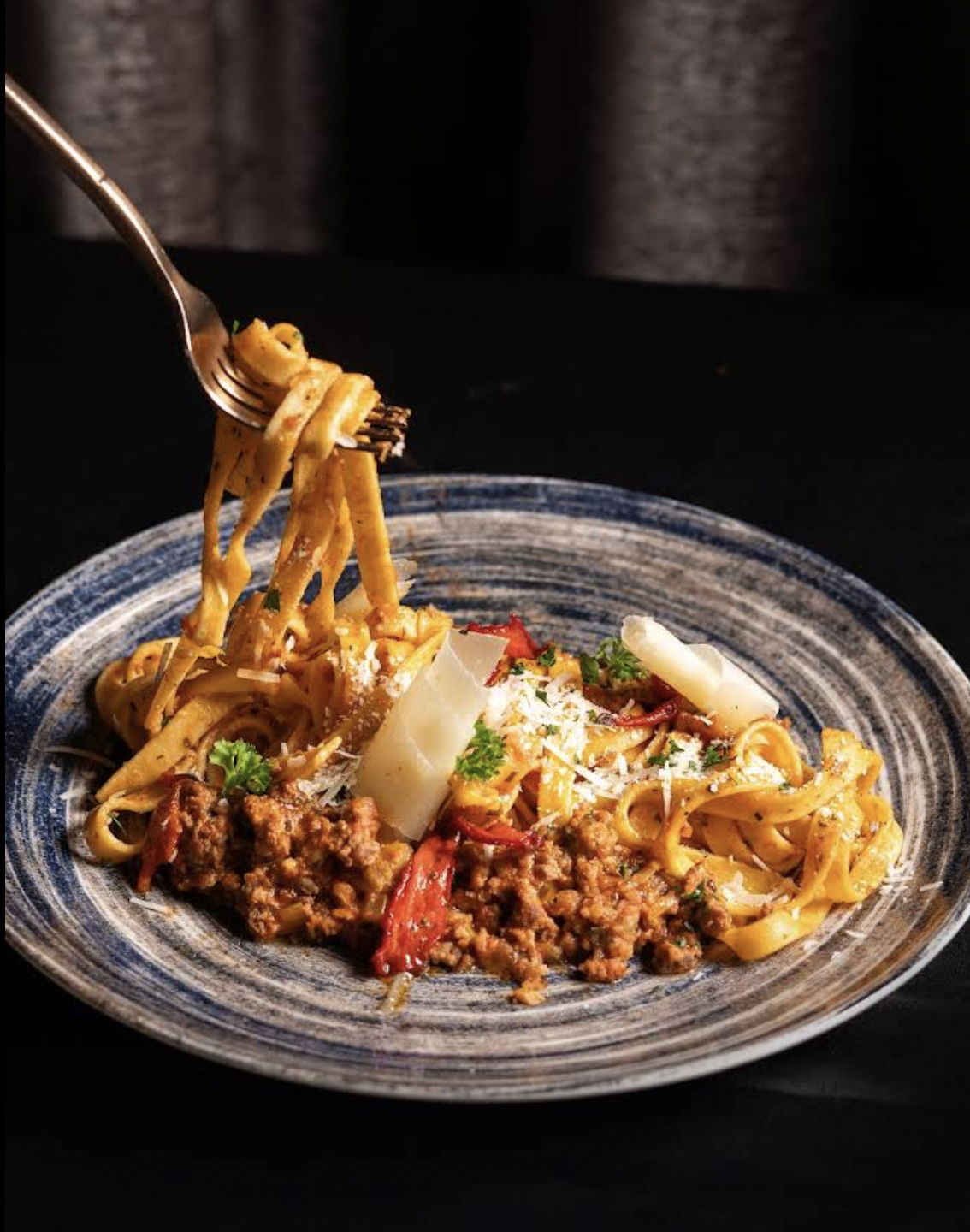 Fresh pasta dish served on a blue ceramic plate